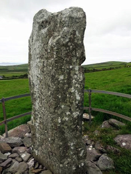 tall, thick ogham stone in a field