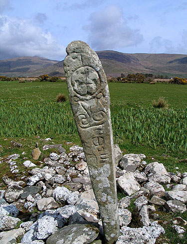 tall, thin ogham stone in a field