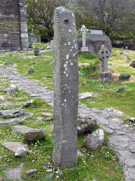 tall, thin ogham stone in old church grounds